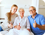 caregiver showing thumbs up with the elderly man and woman