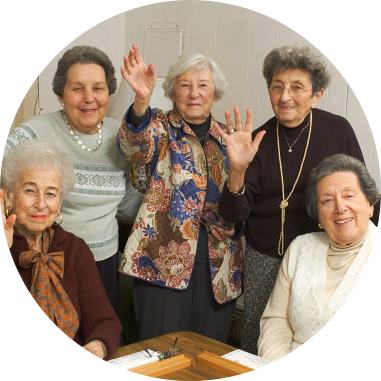 four elderly women waving at the camera